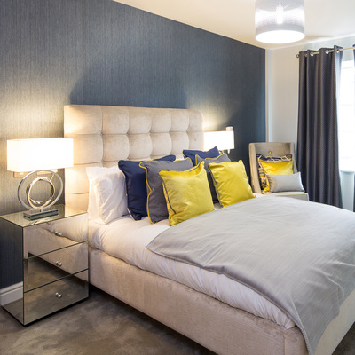 Contemporary bedroom, with navy blue wall, mirror furniture and gold & navy cushions