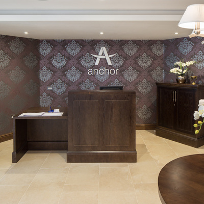 Bespoke reception desk and storage, Purple and silver wallpaper and cream tiled floor