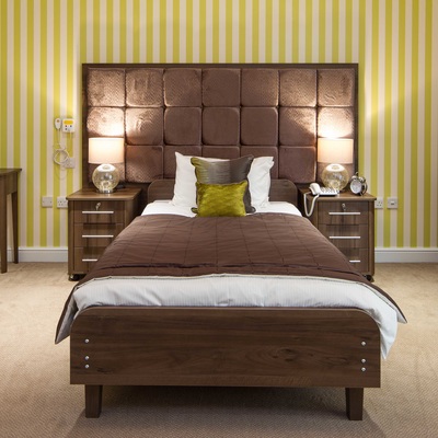 Green and white striped wallpaper, wide care bed and bespoke headboard