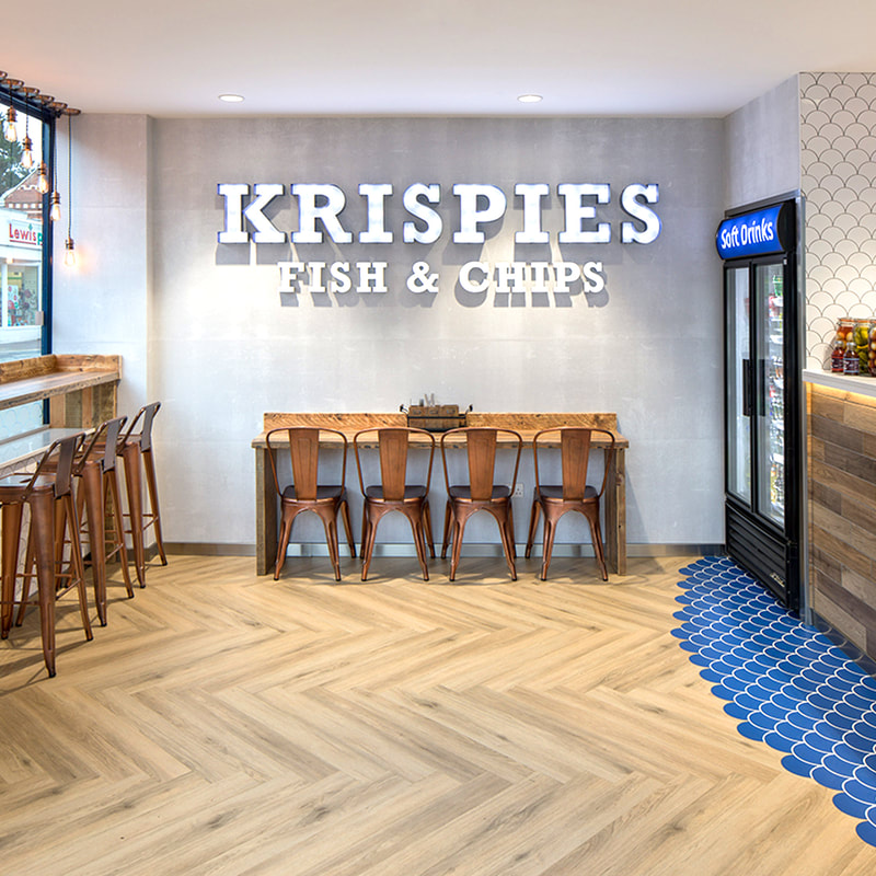 Krispies Fish & Chips shop front, with blue shell shaped floor tiles, copper chairs and industrial lighting.